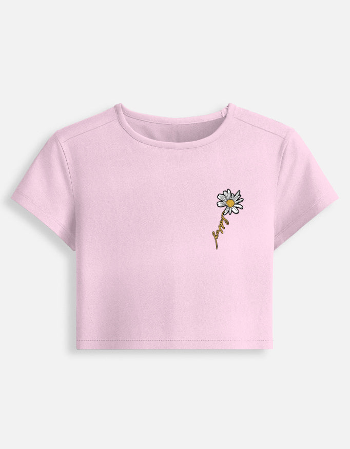 Women's pink crop top featuring a daisy flower graphic design, stylish aesthetic floral cropped T-shirt.