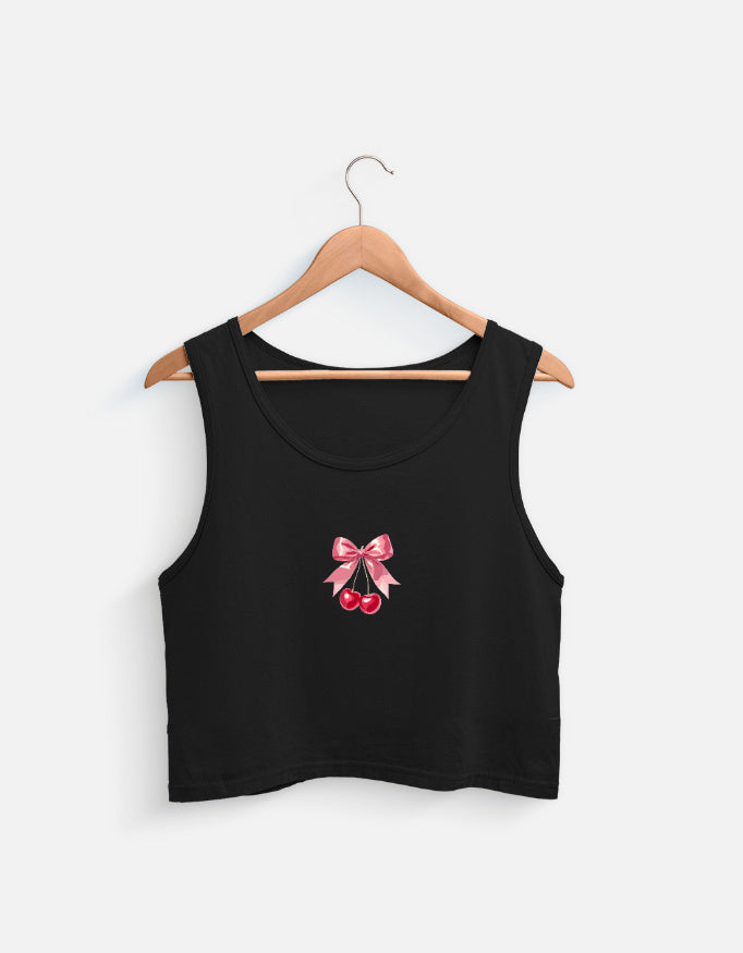 Black women's crop tank top with pink bow and cherry graphic design hanging