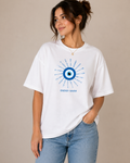 Women wearing white oversized t shirt with blue evil eye energy saver graphic design on chest