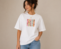 Women wearing white oversized graphic t shirt with minimal floral stripe design on front