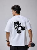 Man wearing white oversized gym t-shirt with One More Rep dumbbell back graphic design.