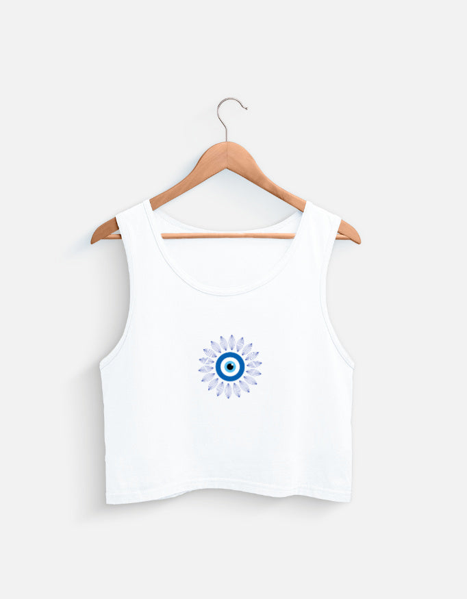 White cotton crop top with blue evil eye graphic on a wooden hanger