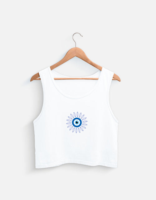 White cotton crop top with blue evil eye graphic on a wooden hanger